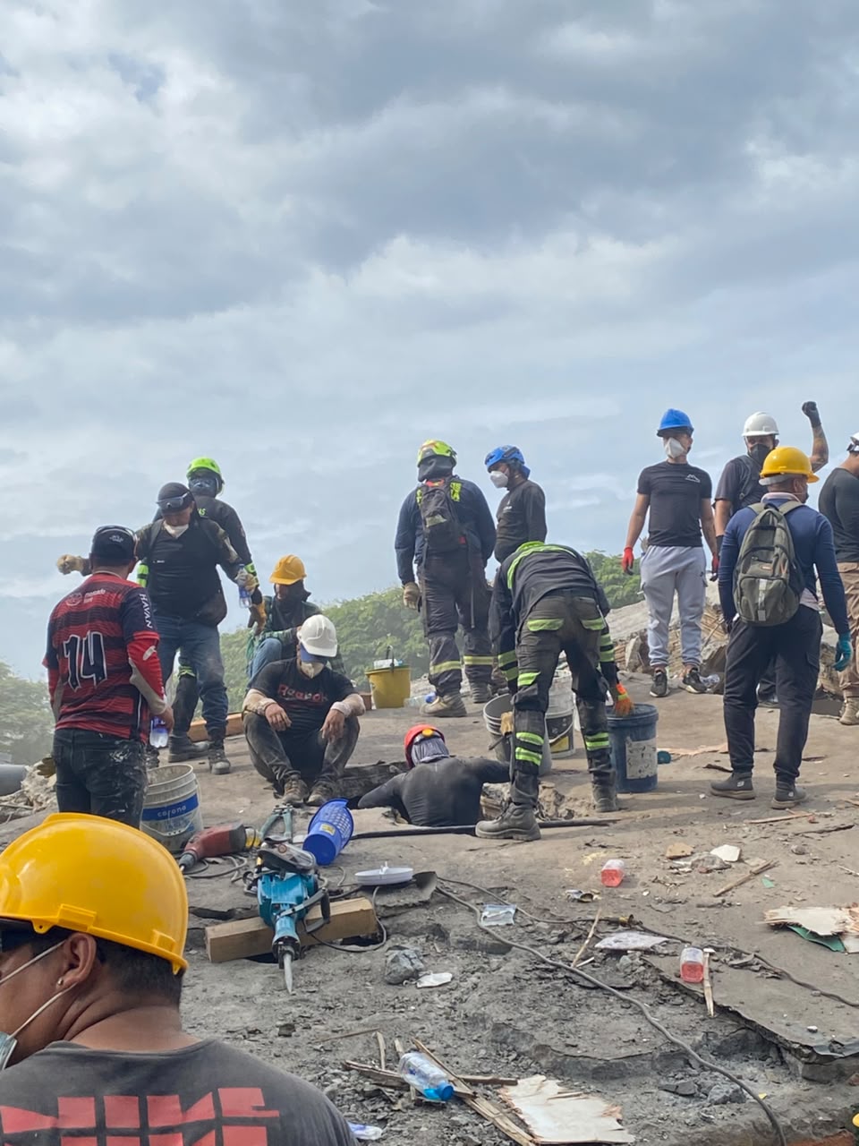 Equipos de socorro y voluntarios trabajando sobre una estructura colapsada